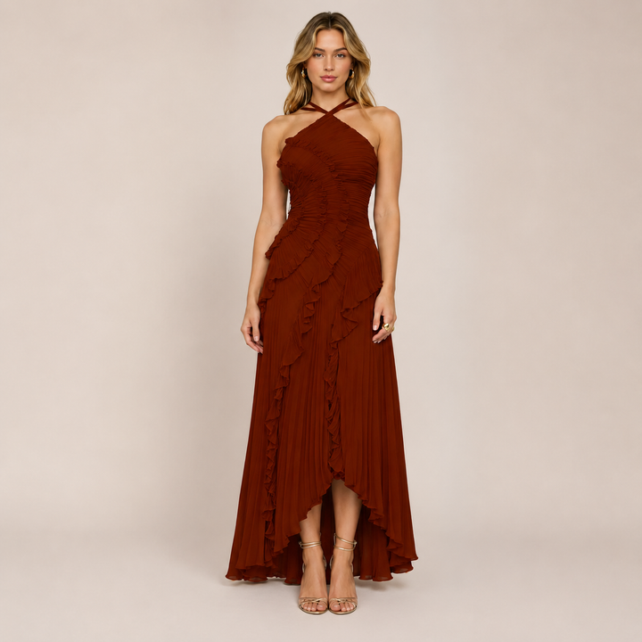 Woman wearing a graceful halter neckline dress on a plain background.