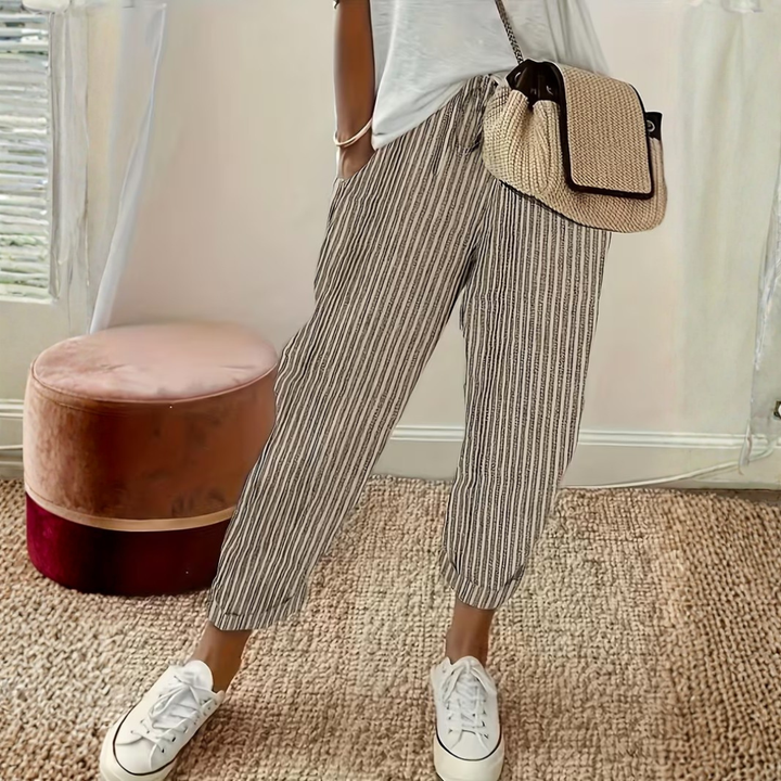 Female model wearing striped wide leg pants against a plain background.
