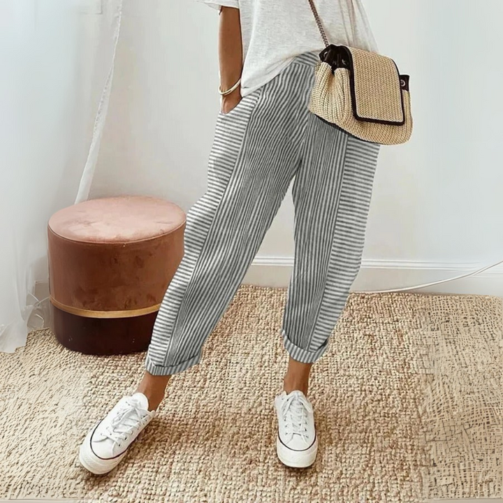 Female model showcasing high waist striped wide leg pants on a plain background.