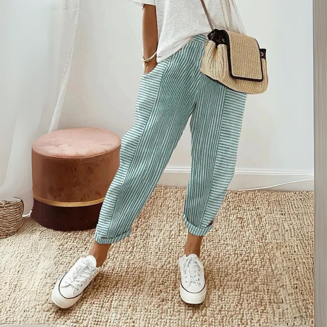 Woman wearing casual striped wide leg pants with side pockets on a plain background.
