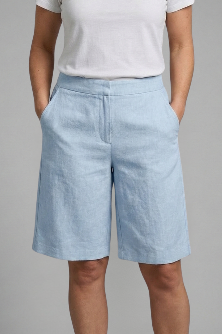 Woman modeling relaxed elastic waist shorts with practical side pockets.