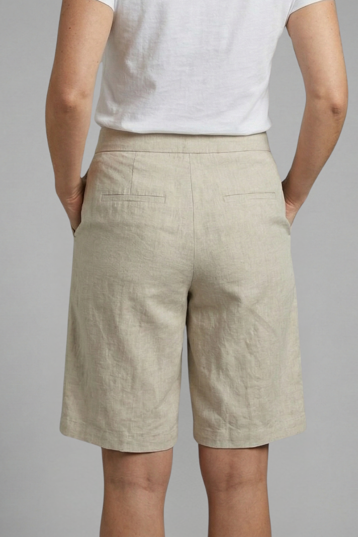 Woman wearing comfortable knee length shorts with a relaxed silhouette on a plain background.