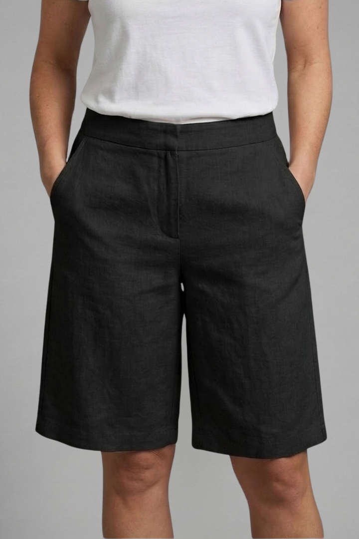 Casual women’s knee length shorts displayed on a female model in a plain studio.