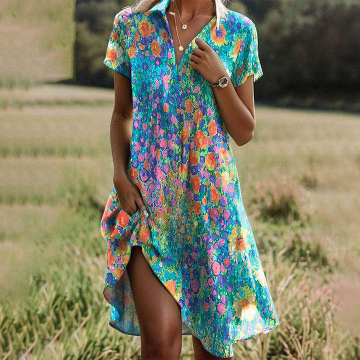 Female wearing a flowing printed dress against a plain background.