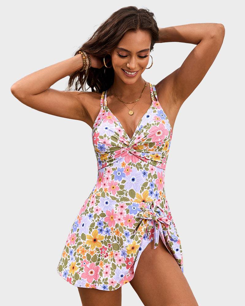 Female presenting a skirted swim dress with a refined front knot accent on a plain background.