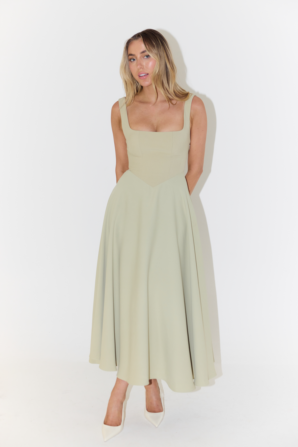 Female in a polished sleeveless satin dress suitable for special occasions on a clean background.
