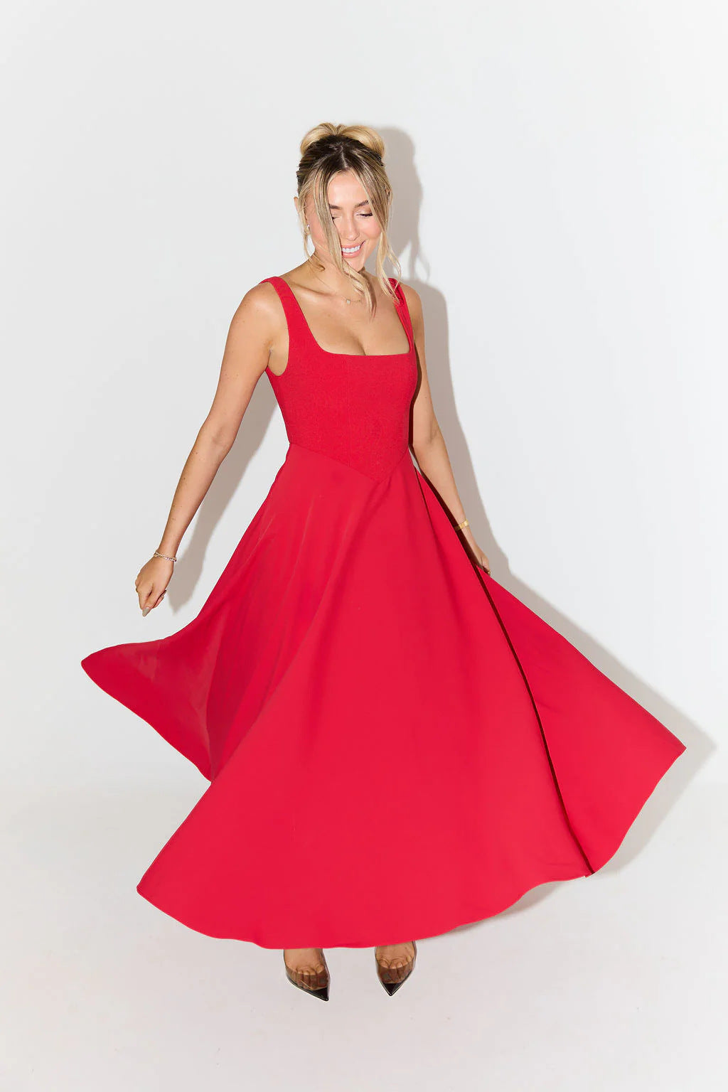 Female wearing a stylish satin midi dress designed for cocktail evenings on a plain background.