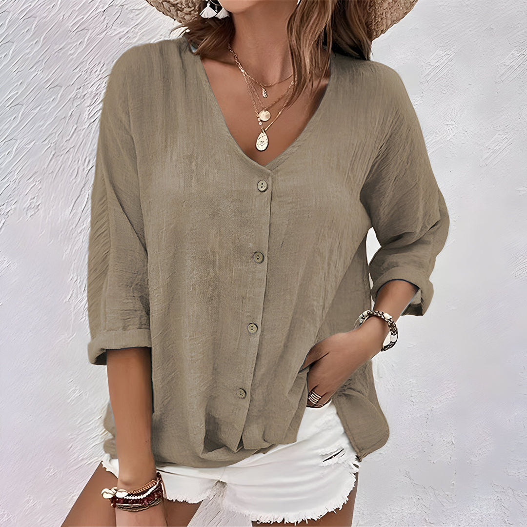 Elegant women’s blouse on a plain background featuring soft fabric and refined buttons.