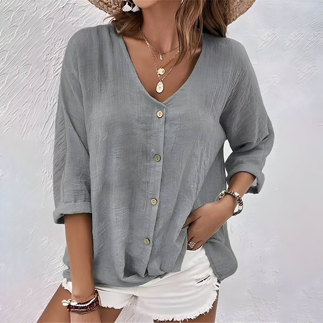 Flowy women’s blouse shown on a clean background with a gently curved hem.