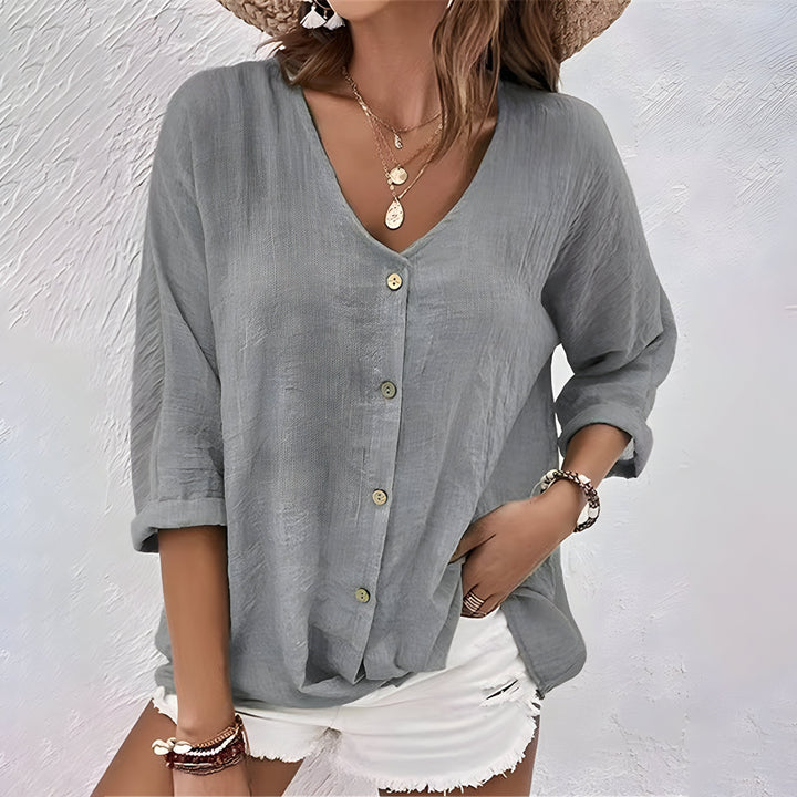 Flowy women’s blouse shown on a clean background with a gently curved hem.