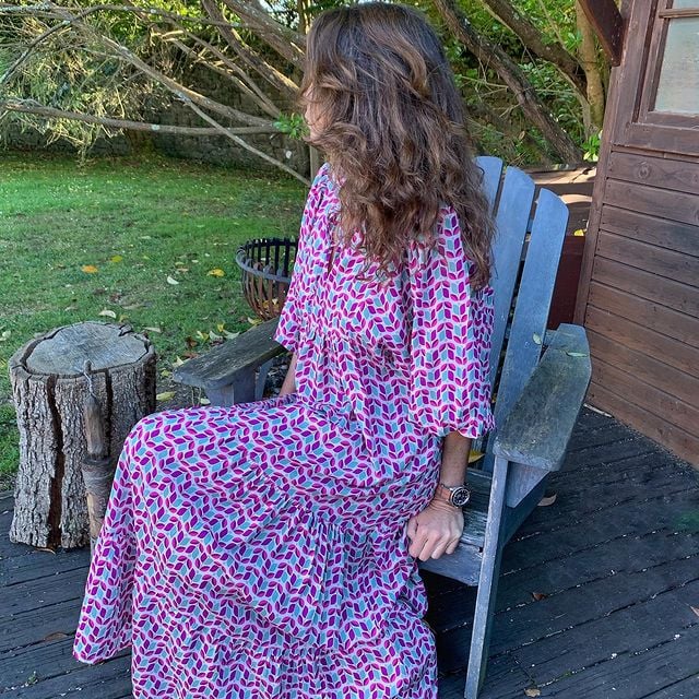 Maxi dress with puff sleeves and ankle-length silhouette shown on a female model seating