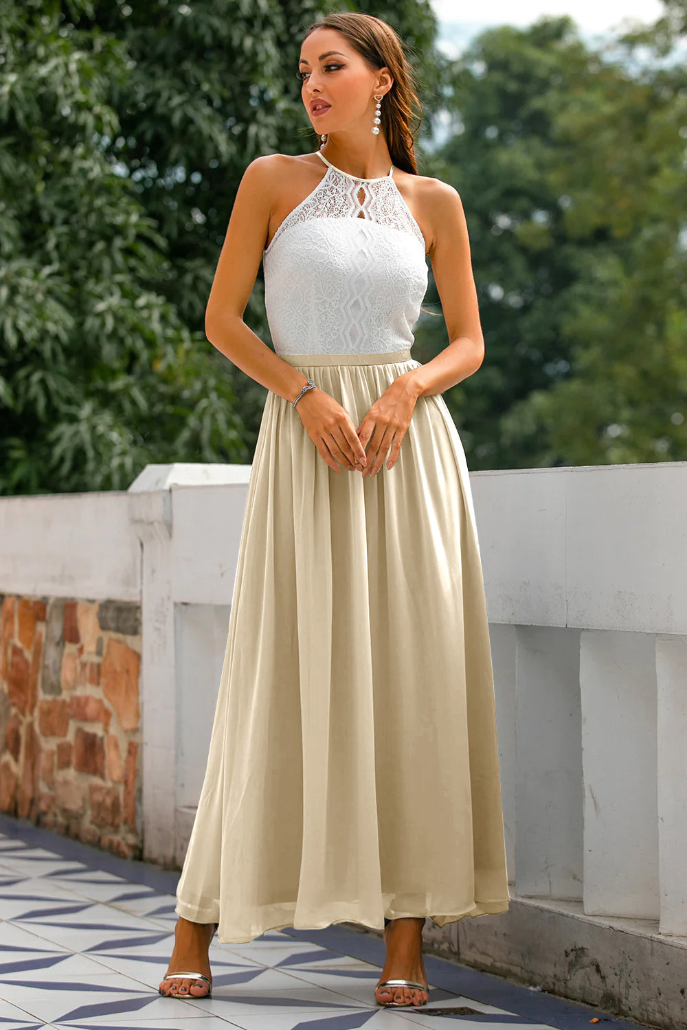Female model displaying halter neckline dress in outdoor setting.