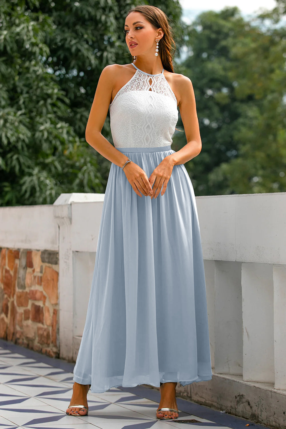 Female model wearing formal maxi outfit in garden pathway.