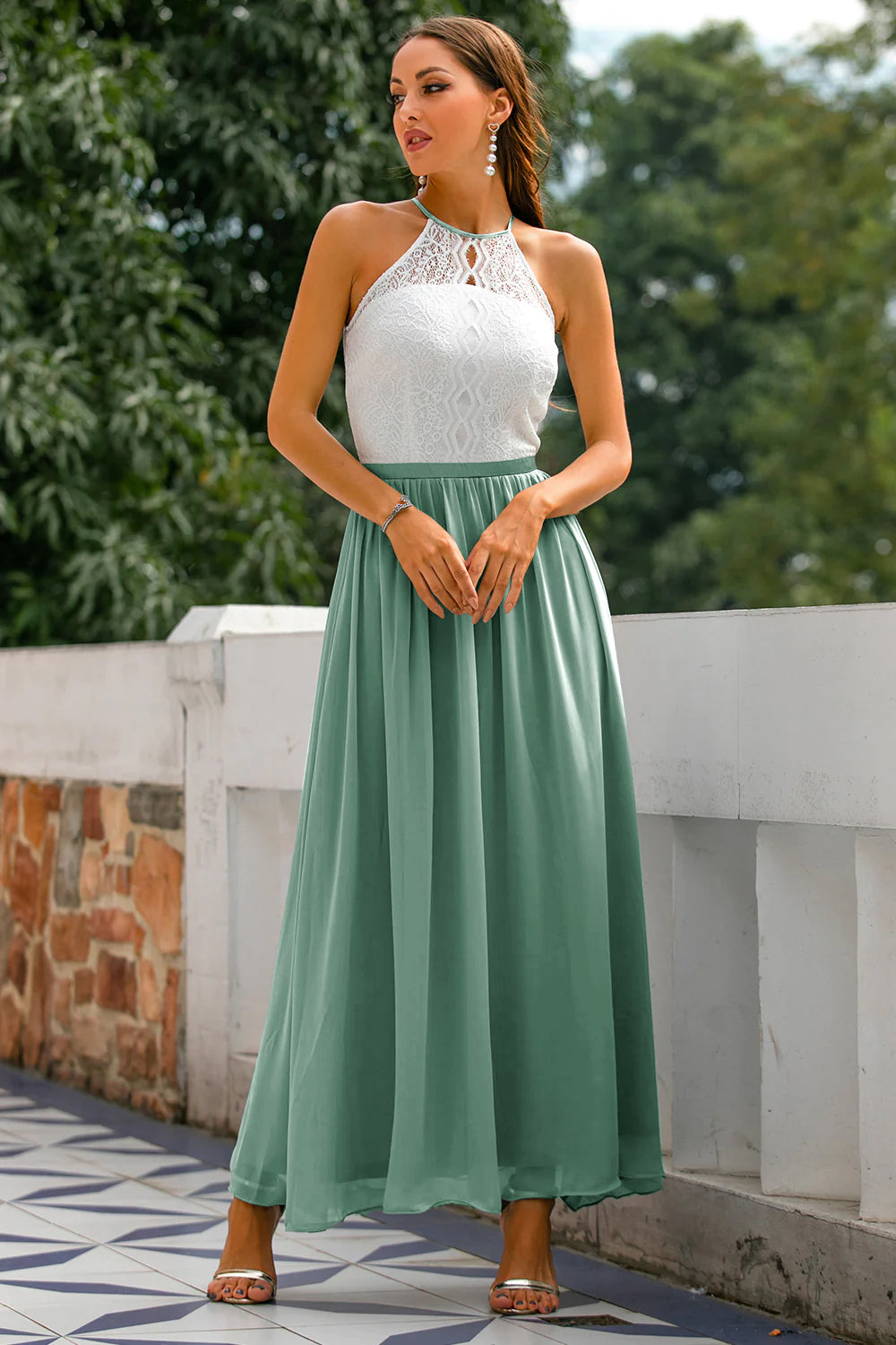 Woman wearing sophisticated long dress with terrace view behind.
