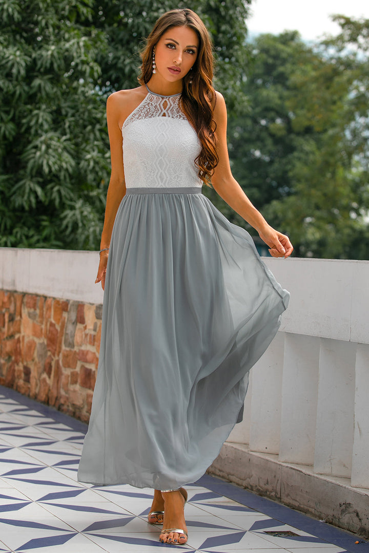 Woman wearing elegant halter maxi dress in terrace garden setting.