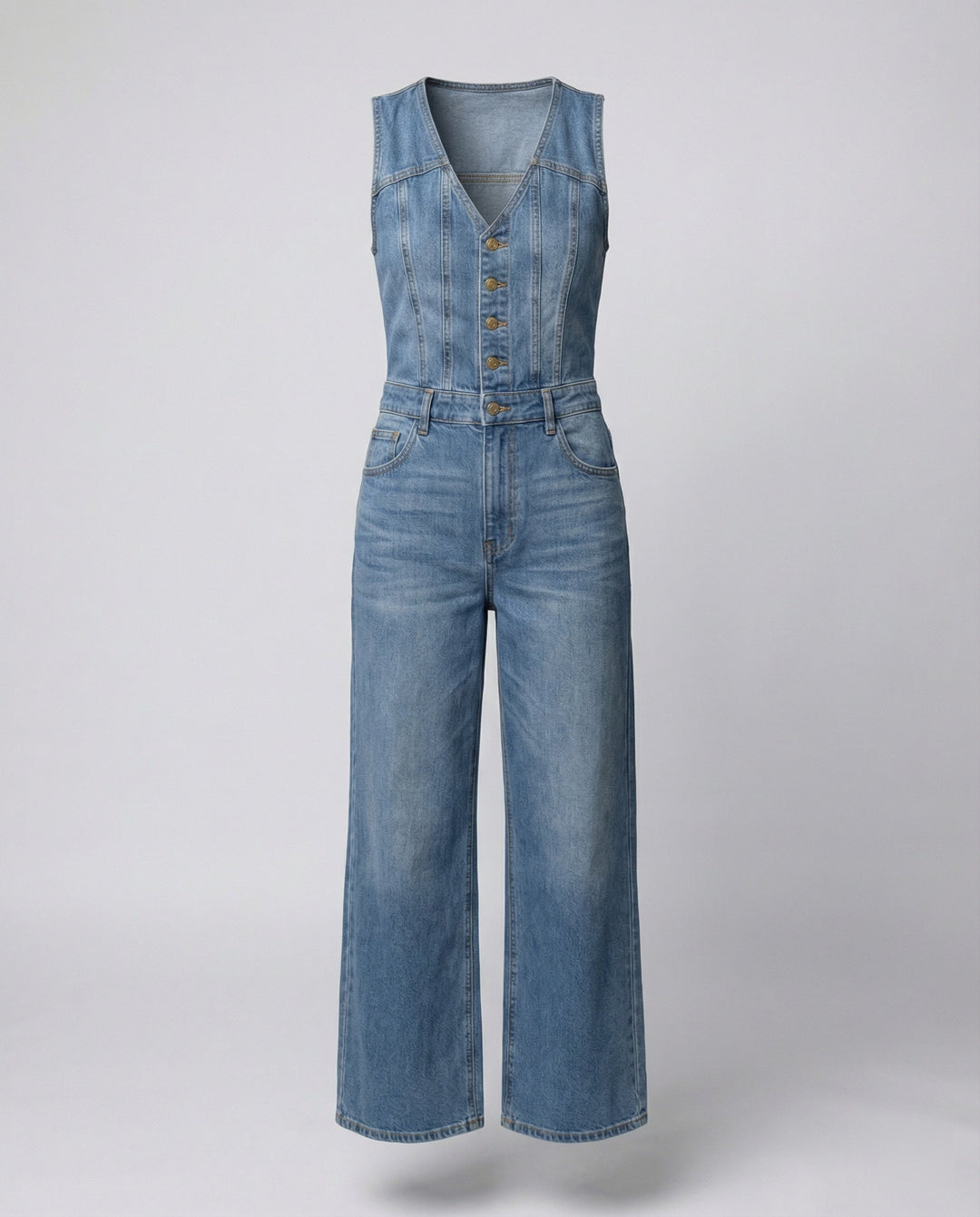 A relaxed denim one-piece outfit with a flowing silhouette on a plain background.