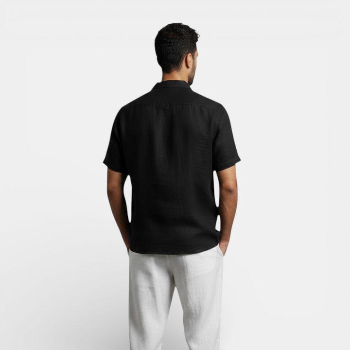  Female model wearing a relaxed short sleeve shirt on a plain background.