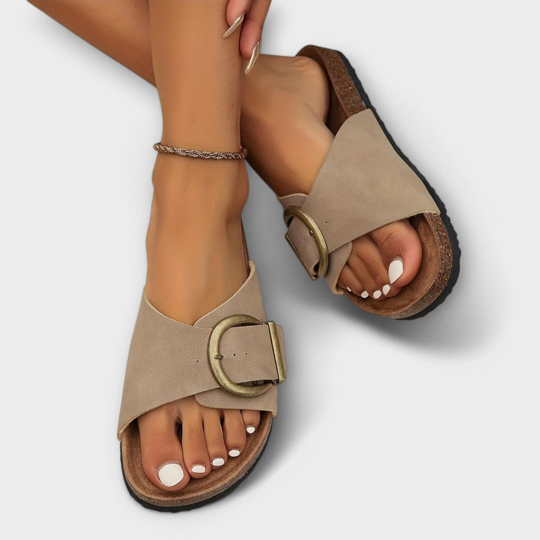 Women’s sandals displayed on a female model with a clean plain background.