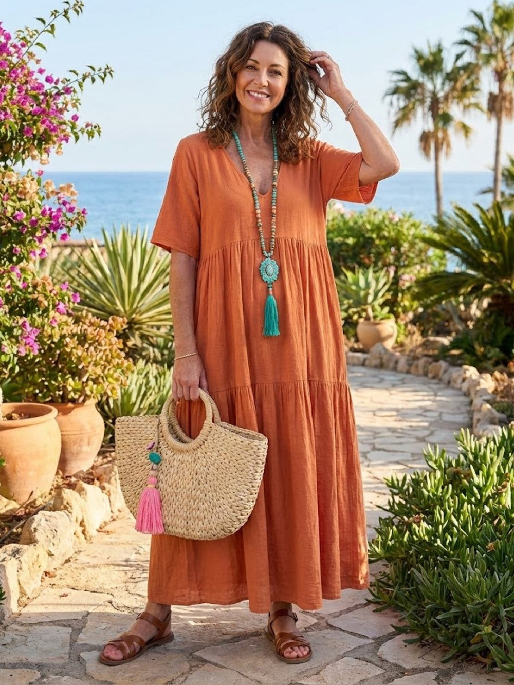 Female model in a flowing V-neck maxi dress styled on a plain background.