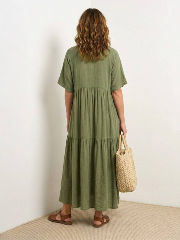 Female wearing a boho-inspired maxi dress with layered skirt detailing on a plain background.