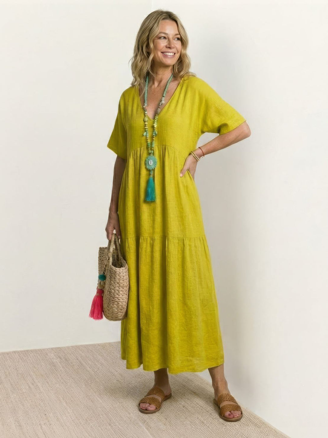 Woman wearing a lightweight-inspired flowing dress with a loose fit on a plain background.