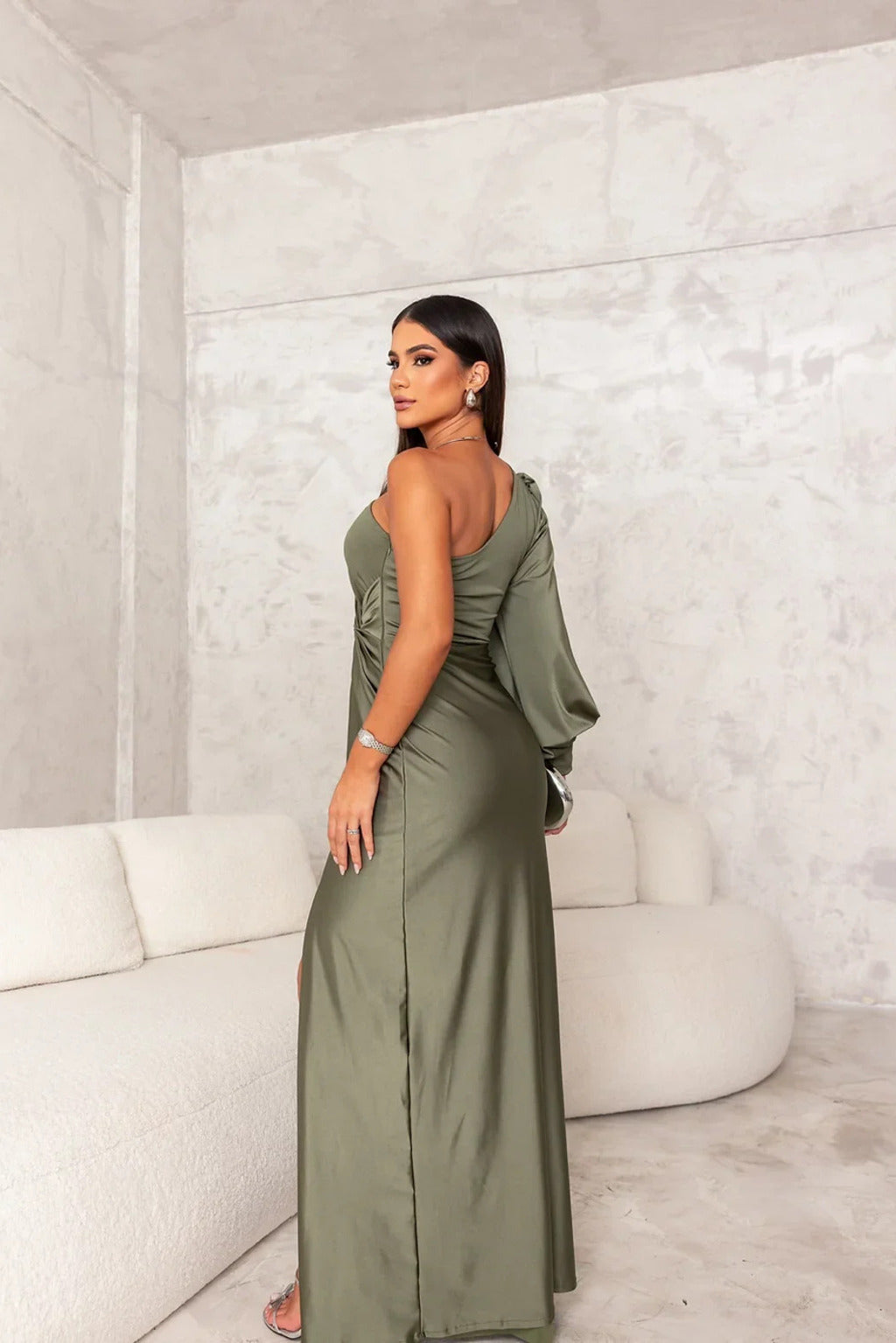 Female model wearing a classic long dress with graceful shape against a plain background.