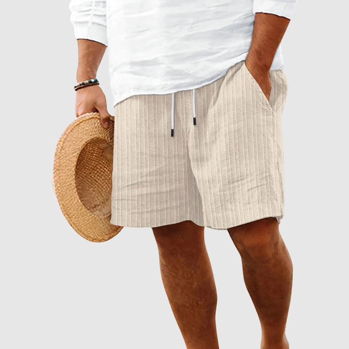  Male model showing lightweight drawstring shorts with side pockets on a plain background.