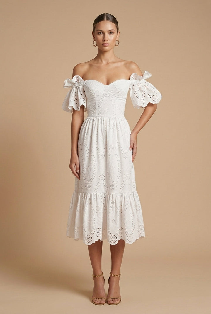 Female model posing in a long-sleeve dress with decorative buttons against a plain background.