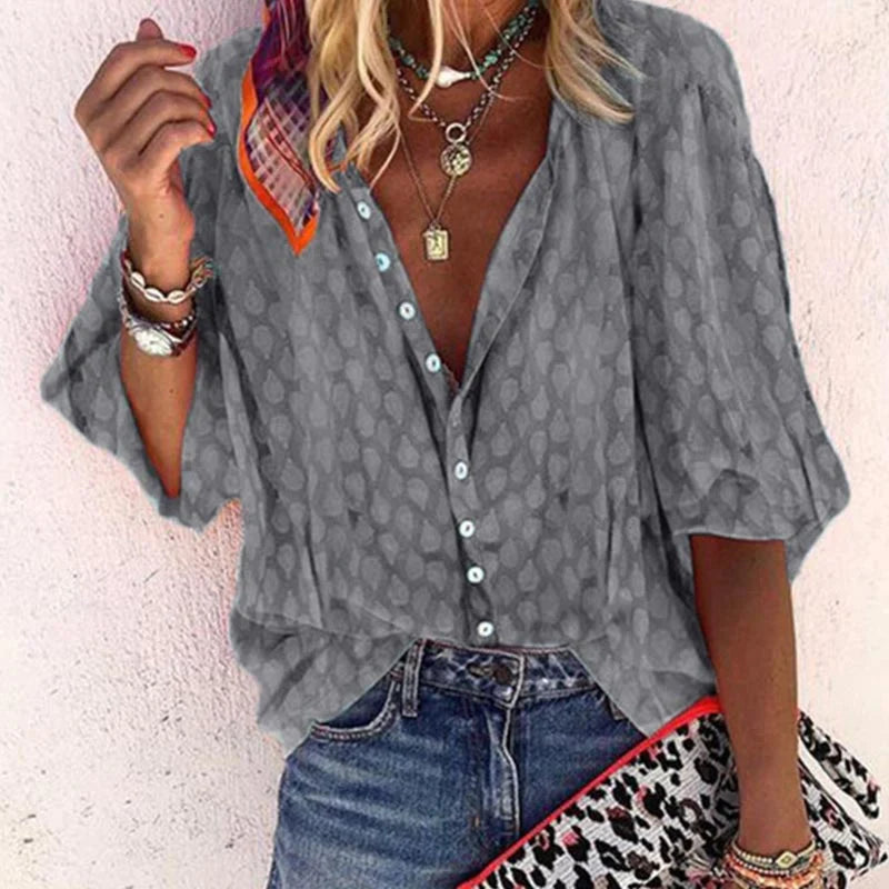 Airy summer blouse hanging against clean plain background