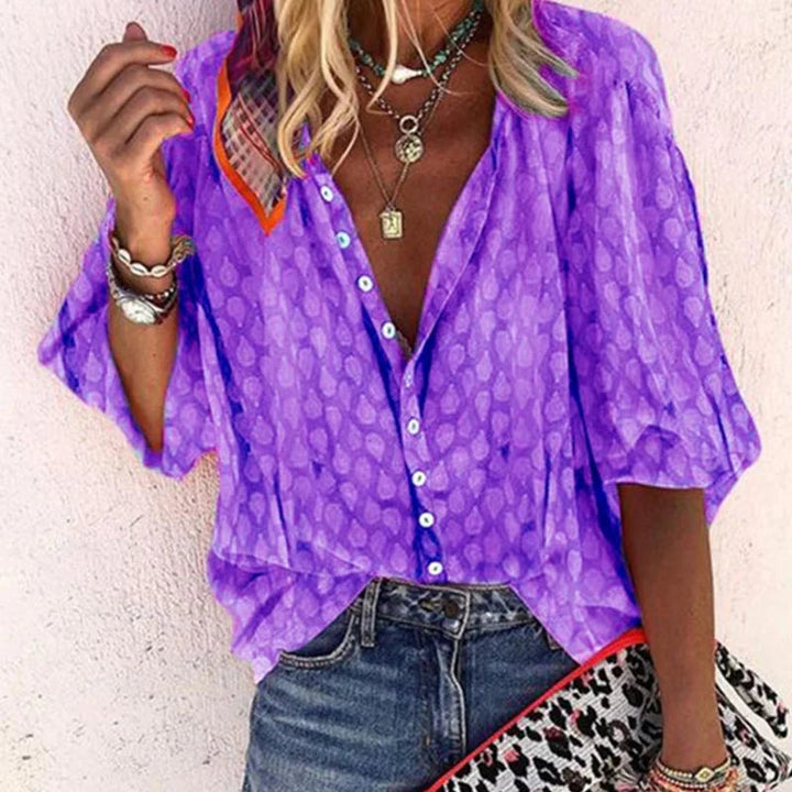 Loose fit blouse showing flowy cut on simple background
