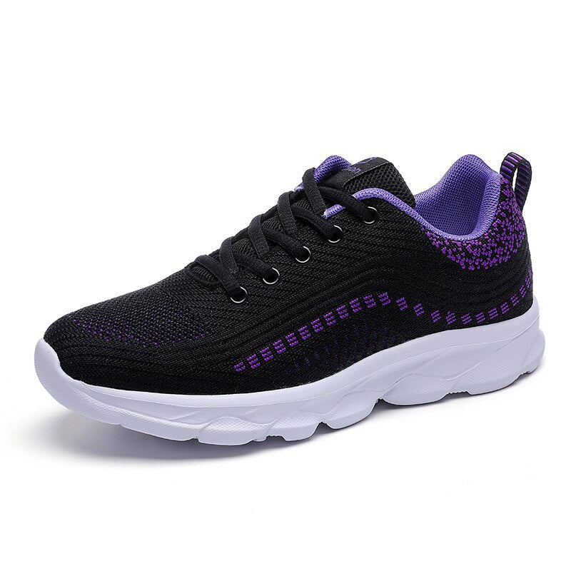 Female model wearing lightweight supportive walking shoes on a plain background.