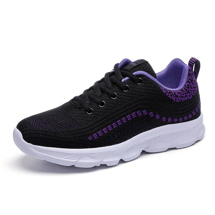 Female model wearing lightweight supportive walking shoes on a plain background.