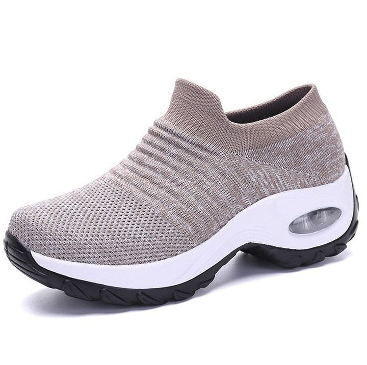 Woman displaying lightweight everyday shoes on a clean plain background.