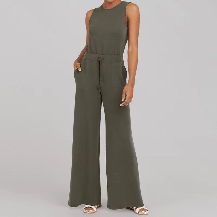 Female model wearing a chic jumpsuit with a defined waist on a plain background.