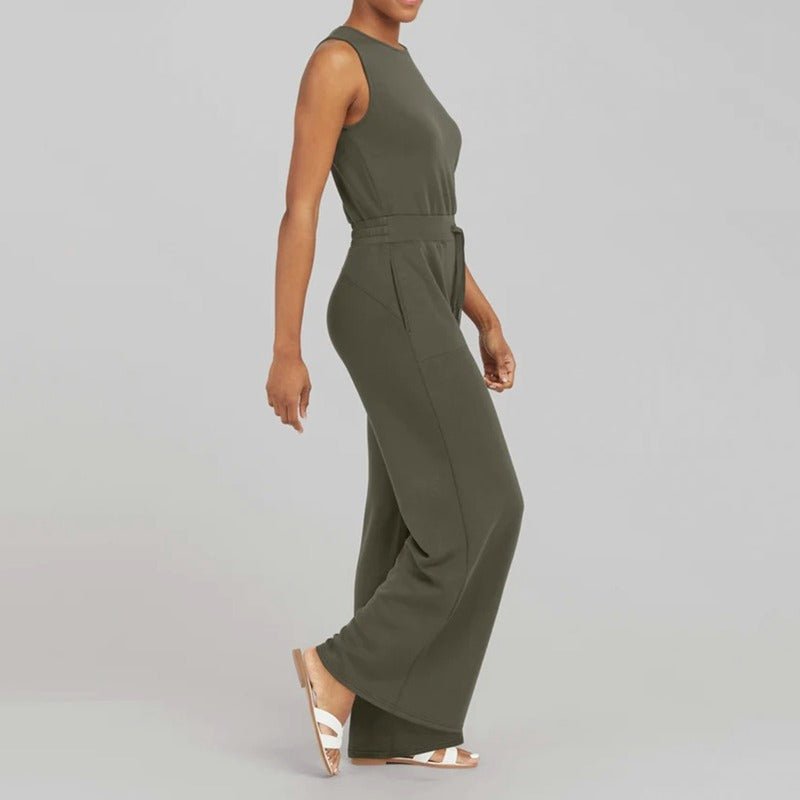 Female model wearing a polished jumpsuit with a graceful neckline on a plain background.