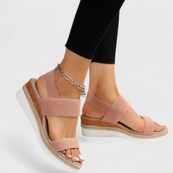 Female presenting versatile wedge sandals with an open design on a plain background.