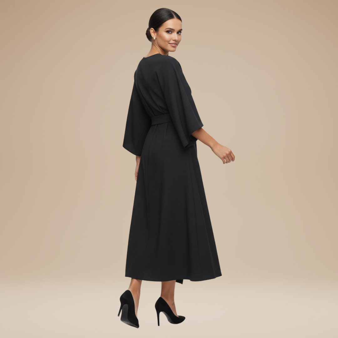 Model wearing a refined wrap midi dress with draped waist styling on a plain background.
