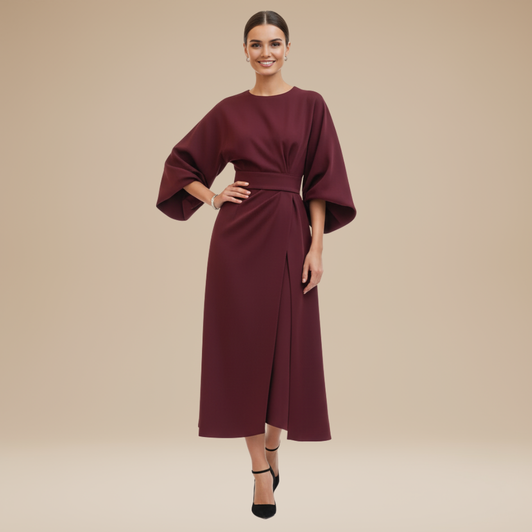 Female model in a belted midi dress with feminine wrap detail on a plain background.
