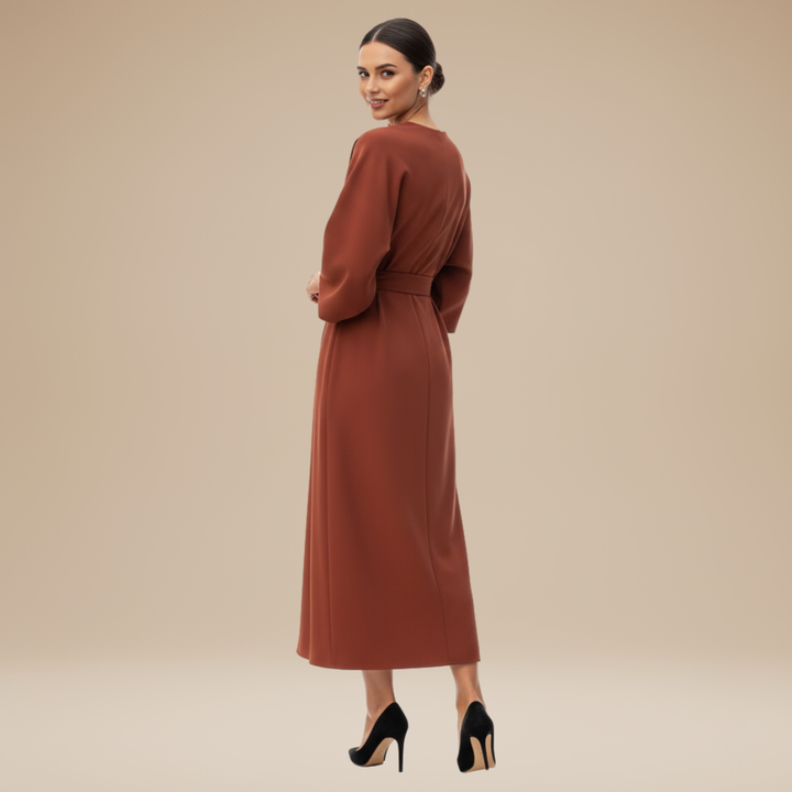 Woman in a feminine midi dress with draped wrap styling on a plain background.