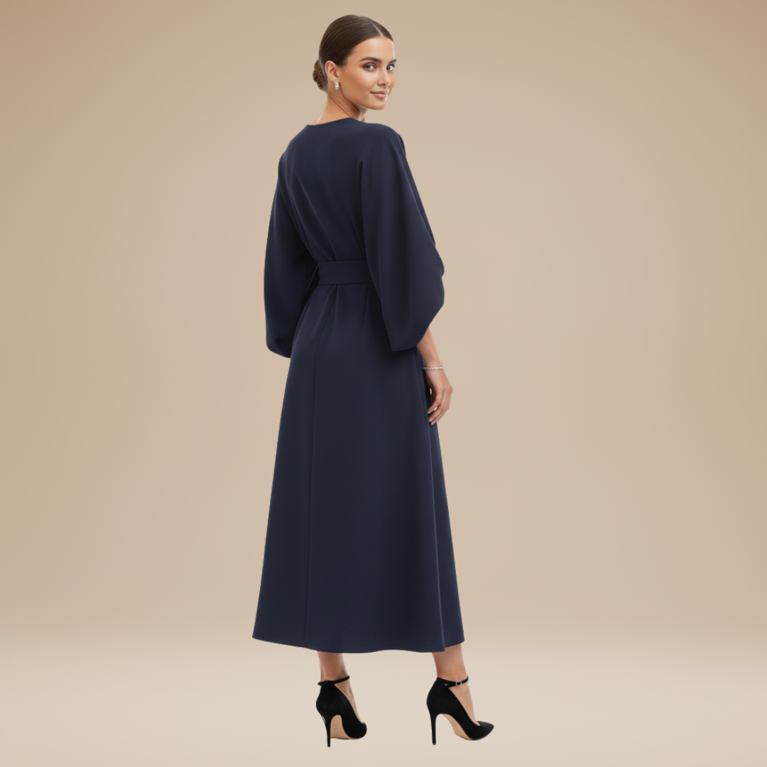 Model wearing an elegant midi dress with belt detail and flowing sleeve design on a plain background.