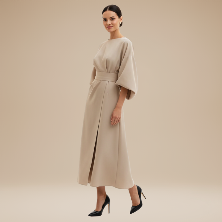 Female model showcasing a belted midi dress with wrap styling on a plain background.