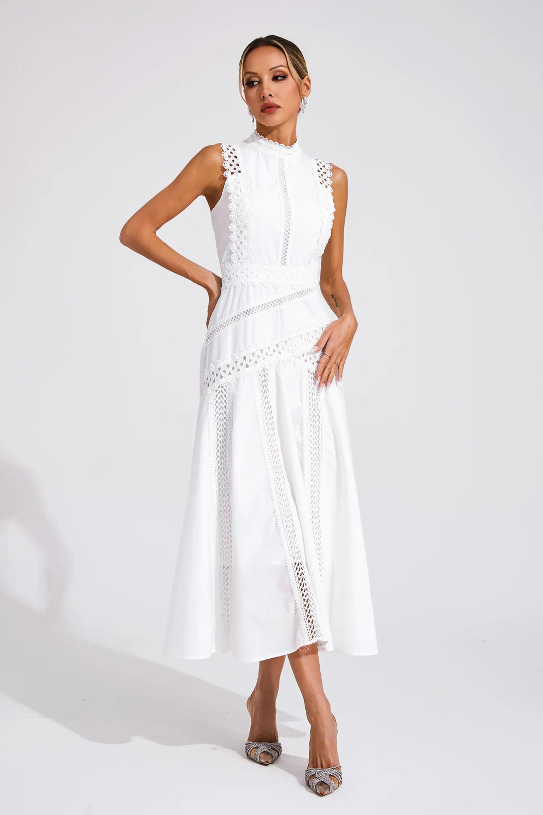 Female modeling a polished midi dress with a structured upper design and airy skirt against a plain background.