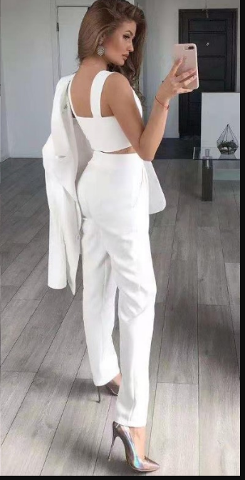  Woman wearing a dressy two piece pants outfit on a plain background