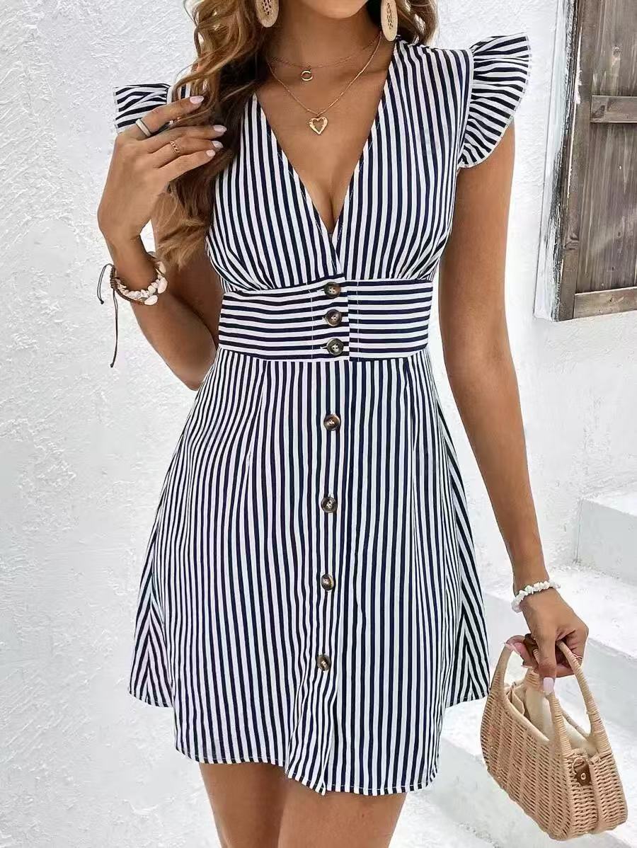 Woman wearing a breathable A-line dress with soft ruffle cap sleeves on a plain background.