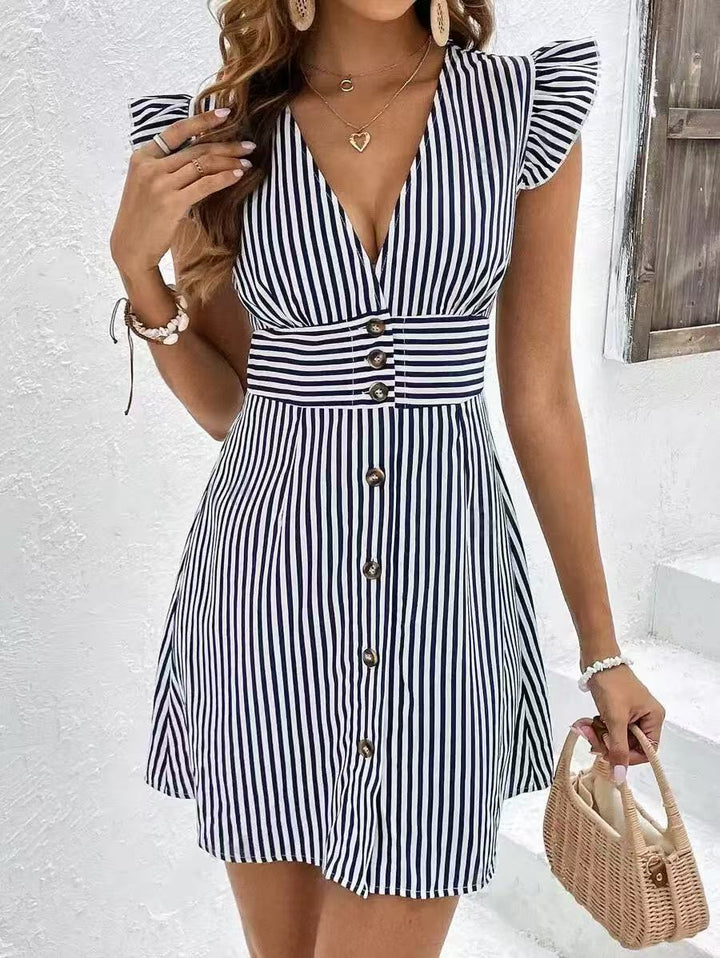 Woman wearing a breathable A-line dress with soft ruffle cap sleeves on a plain background.