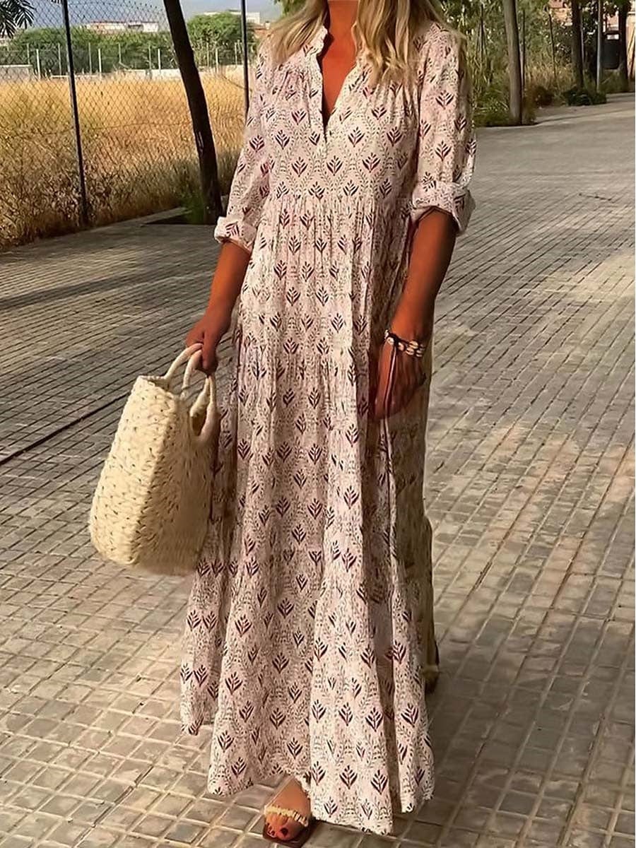 Woman wearing a bohemian V-neck maxi dress against a side walk nature background.