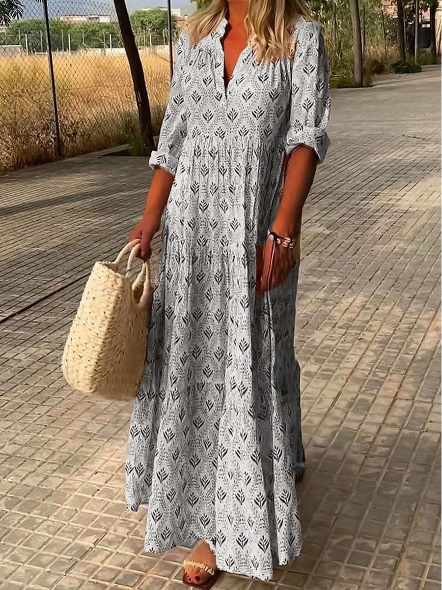 Female wearing a V-neck long dress with 3/4 sleeves on a side walk background.
