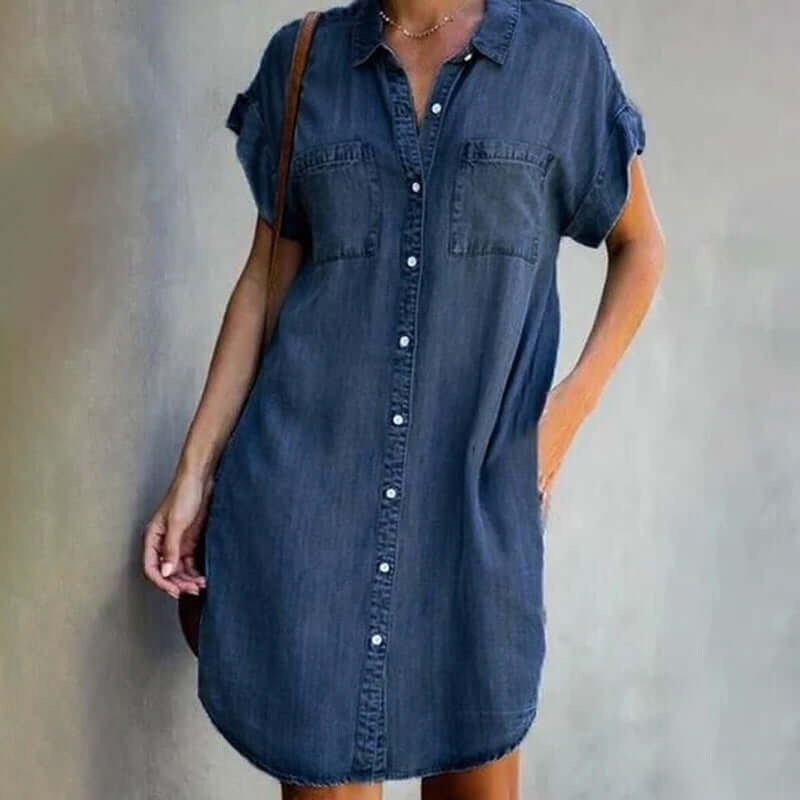 Model in a button-down denim shirt dress with a relaxed knee-length fit.