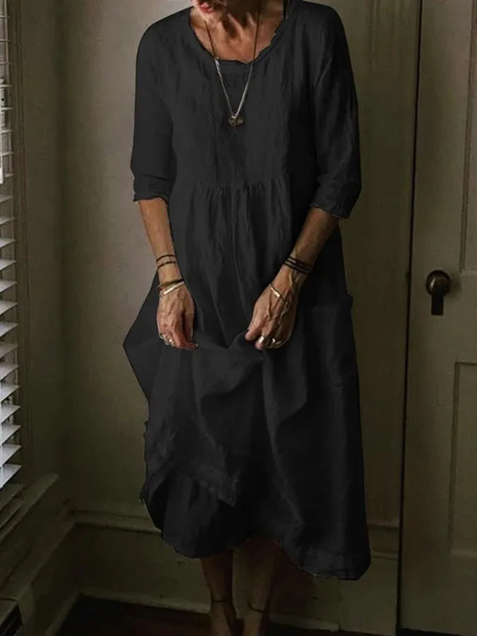 Model in a relaxed midi dress with 3/4 sleeves on a clean background.