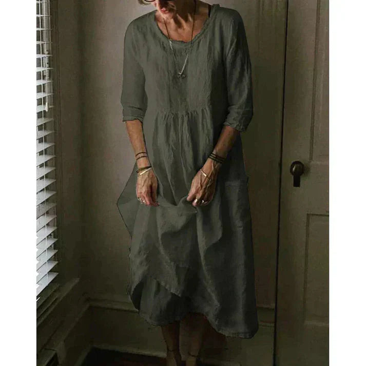 Female in a loose fit midi dress with side pockets on a clean background.